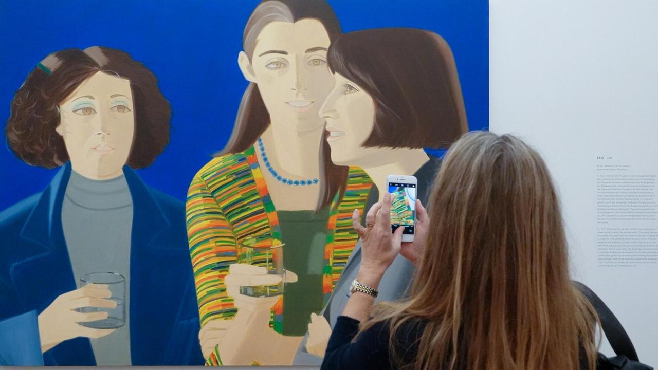 05.12.2018, Bayern, München: Eine Frau fotografiert im Museum Brandhorst während einer Pressevorbesichtigung das Bild "Trio" (1975) in der Retrospektive "Alex Katz". Die Ausstellung "Alex Katz" zeigt vom 06.12.2018 bis zum 22.04.2019 rund 80 Werke des Künstlers. Foto: Katharina Redanz/dpa | Verwendung weltweit