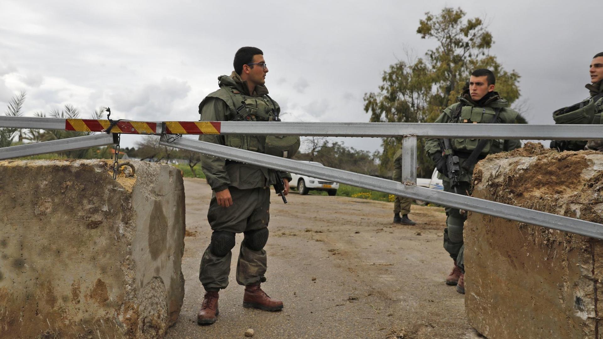 Israelische Soldaten stehen an einer Straßenblockade.