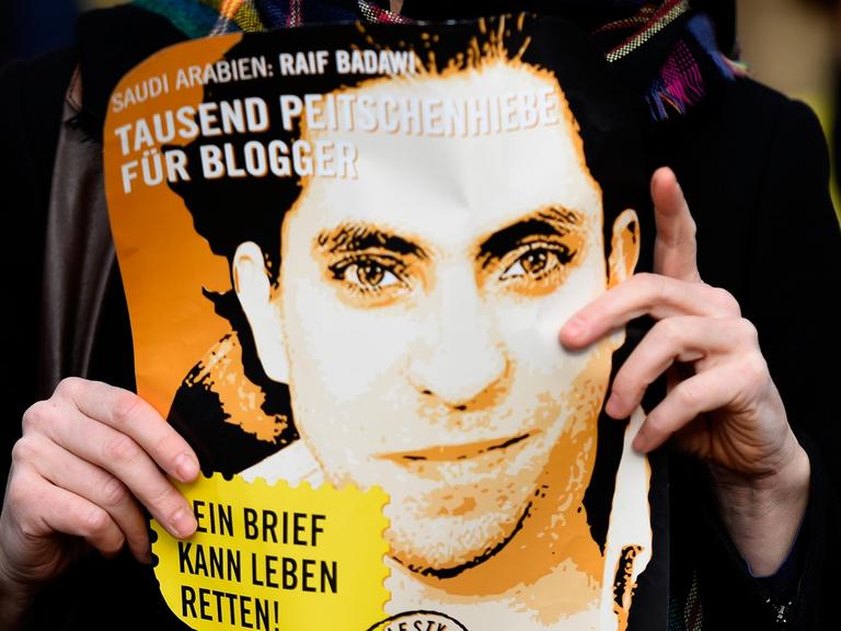 Eine Aktivistin von Amnesty International hält ein Plakat mit Raif Badawi hoch und fordert dessen Freilassung bzw. das Ende der Prügelstrafe vor der saudi-arabischen Botschaft in Deutschland am 29. Januar 2015.