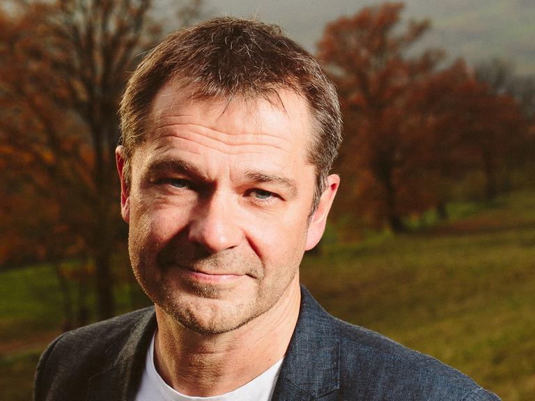 Der Kabarettist und Hüsch-Biograf Martin Buchholz vor einer Herbstlandschaft