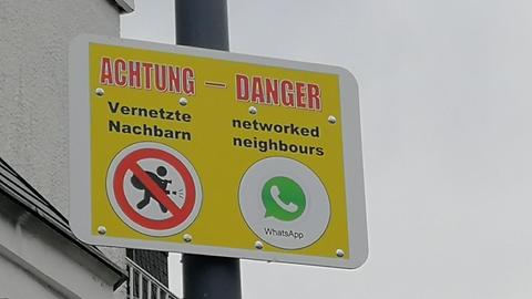 Schild mit einer Warnung / Nachricht in deutsch und englisch: Achtung Vernetzte Nachbarn und danger networked neighbours