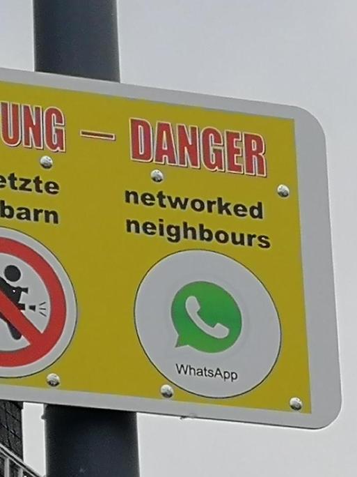 Schild mit einer Warnung / Nachricht in deutsch und englisch: Achtung Vernetzte Nachbarn und danger networked neighbours