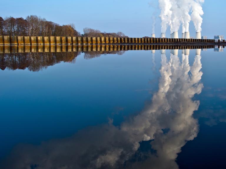 Wasserdampf steigt aus den Kühltürmen eines Braunkohlekraftwerkes in Jänschwalde und spiegelt sich dabei in einem abgelassenen Fischteich. Die Kraftwerkstechnologie ist in der Klima-Debatte schon lange ein Zankapfel. Laut Greenpeace zählt Jänschwalde zu den fünf klimaschädlichsten Braunkohlekraftwerken in Europa.