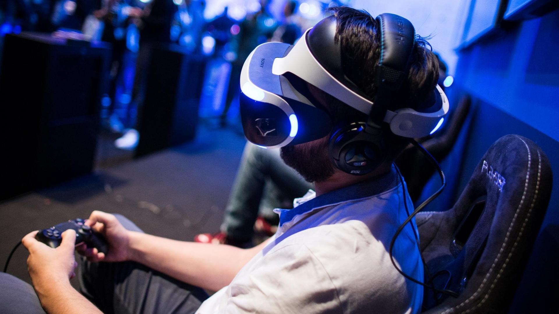 Ein Fachbesucher testet in Köln auf der Spielemesse Gamescom mit der VR-Brille (Virtual Reality) ein Computerspiel.