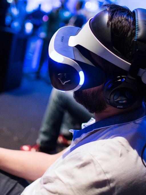 Ein Fachbesucher testet in Köln auf der Spielemesse Gamescom mit der VR-Brille (Virtual Reality) ein Computerspiel.