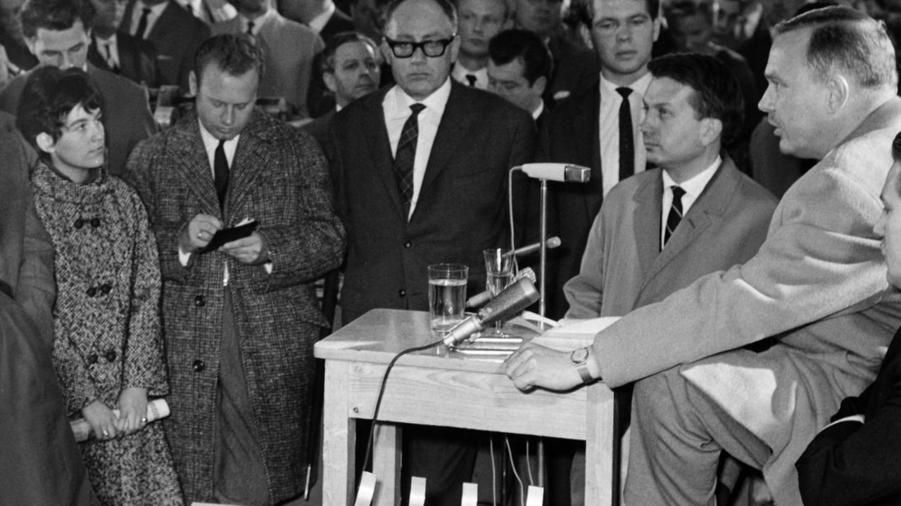 Der Verlagsdirektor des Spiegel, Hans Detlev Becker (r., am Rednerpult), und Spiegel-Chefredakteur Johannes K. Engel (links daneben), am 29.10.1962 auf einer Betriebsversammlung zur "Spiegel"!-Affäre.