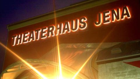 Beleuchteter Schriftzug am Theaterhaus Jena im Dunkeln