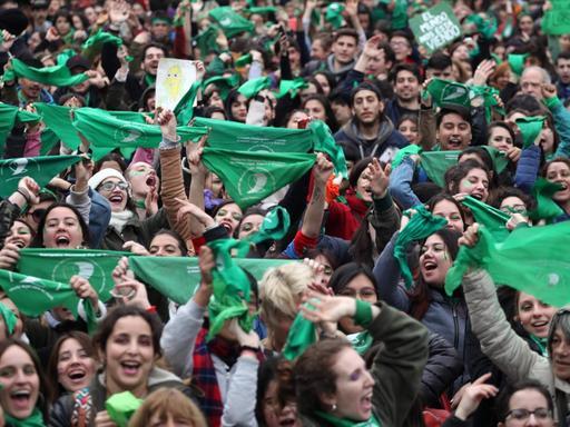 Zum Zeichen ihrer Befüwortung der Legalisierung von Abtreibungen halten viele Menschen grüne Halstücher in die Luft