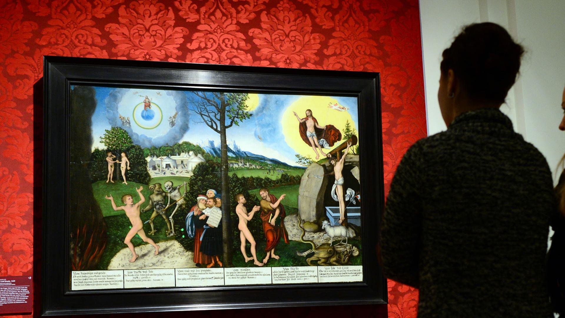 In der Ausstellung "Bild und Botschaft. Cranach im Dienst von Hof und Reformation" betrachten zwei junge Frauen am 26.03.2015 im Herzoglichen Museum in Gotha (Thüringen) das Gemälde "Gesetz und Gnade" von Lucas Cranach d.Ä., gemalt 1529.