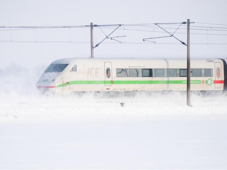 Ein ICE der Deutschen Bahn fährt über die ICE-Trasse Hannover - Berlin und wirbelt Schnee auf.