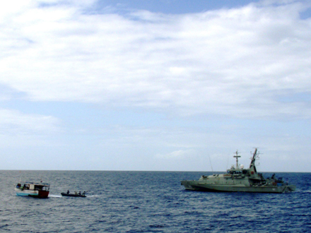 Ein großes Schiff trifft auf ein kleines Flüchtlingsschiff vor Australien.
