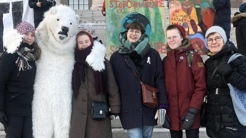 Klimaschutz-Demonstranten vor dem finnischen Parlament in Helsinki, einer trägt ein Eisbärenkostüm.