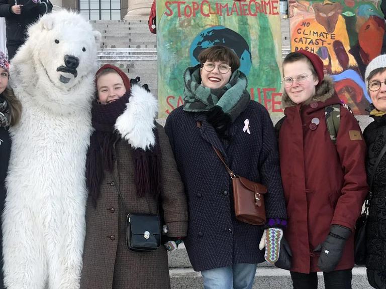 Klimaschutz-Demonstranten vor dem finnischen Parlament in Helsinki, einer trägt ein Eisbärenkostüm.