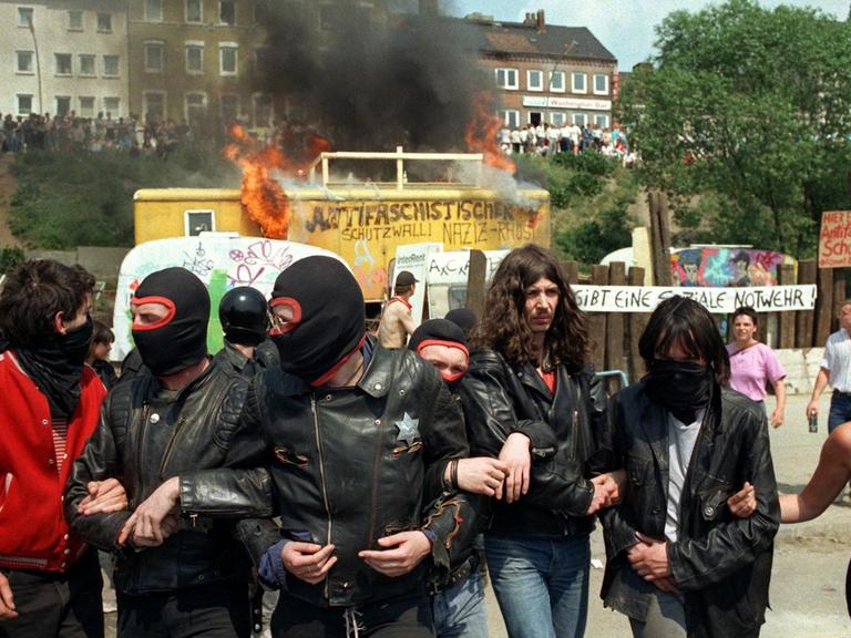 Vermummte Hausbesetzer vor brennenden Wagen der Wagenburg am 26.5.1989 in der Hamburger Hafenstraße.
