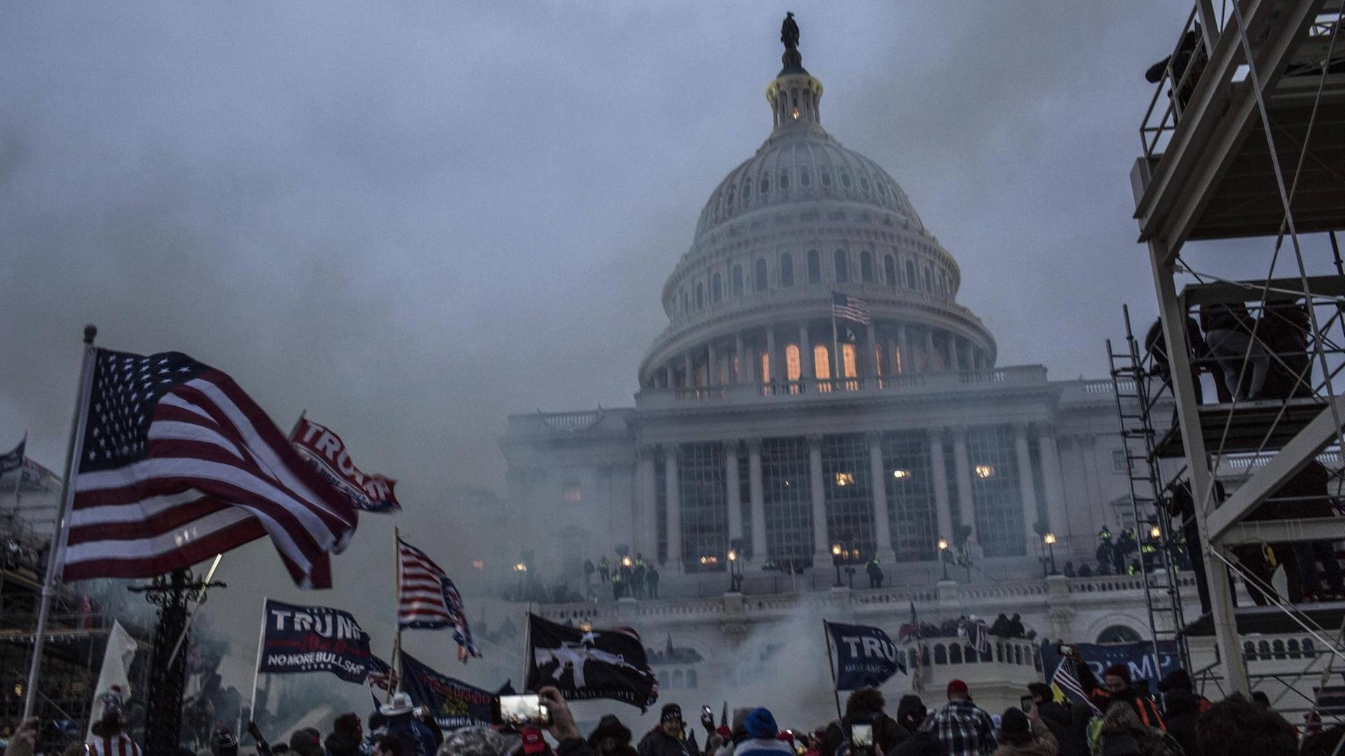 Tränengasschwaden verdunkeln das von Protestlern umlagerte Kapitol in Washington. Tränengasschwaden verdunkeln das von Protestlern umlagerte Kapitol in Washington.