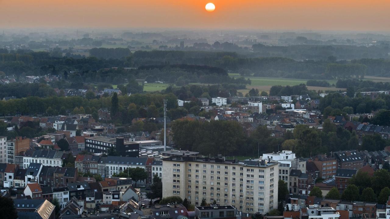 Stadtansicht von Mechelen mit der untergehenden Sonne am Horizont.