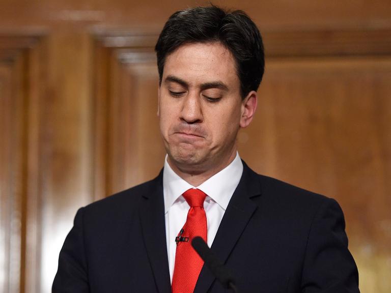 Ed Miliband steht mit verkniffenem Mund und nach unten blickend hinter einem Rednerpult mit der Aufschrift "Labour" .