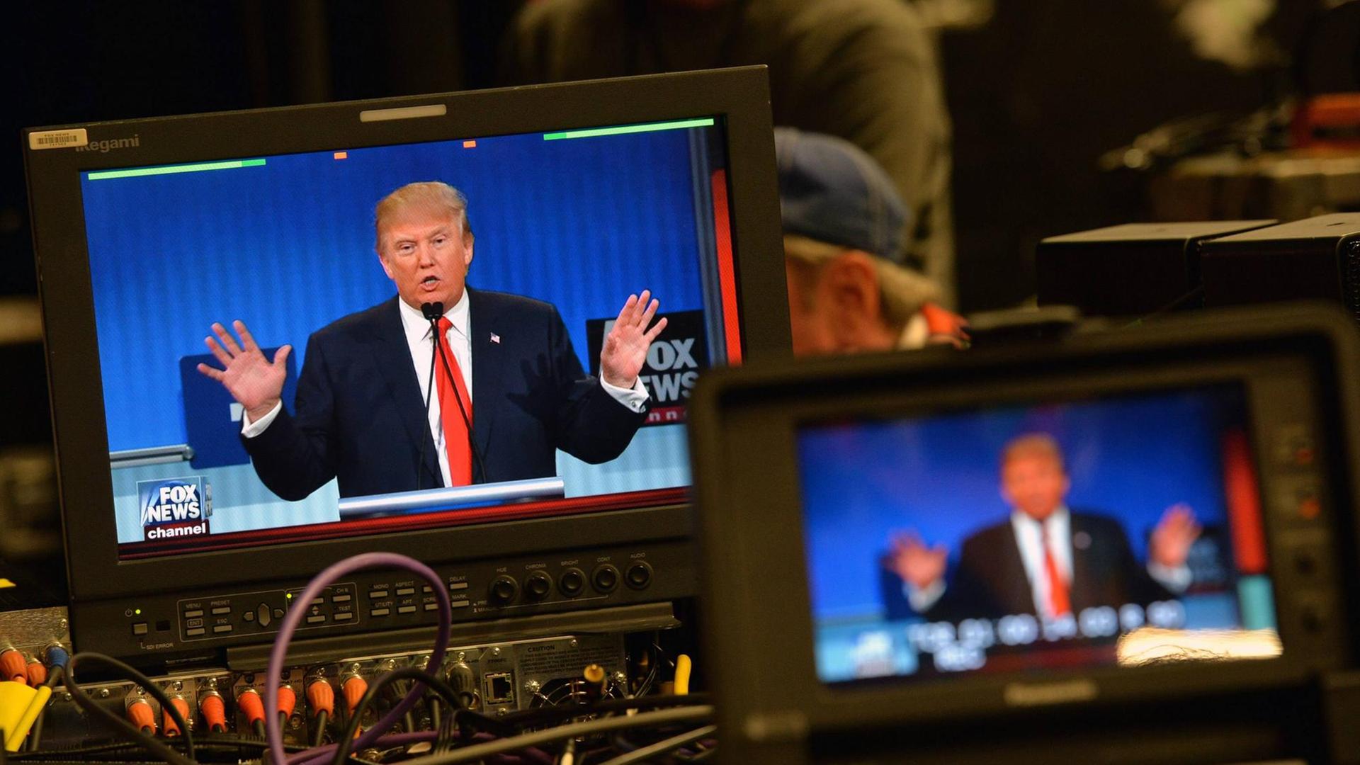 Donald Trump während der ersten großen Debatte der republikanischen Präsidentschaftsbewerber. Man sieht ihn auf einem Fernsehbildschirm.