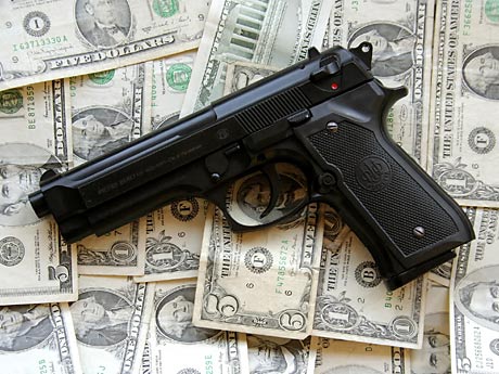 Eine Pistole liegt auf Geldscheinen