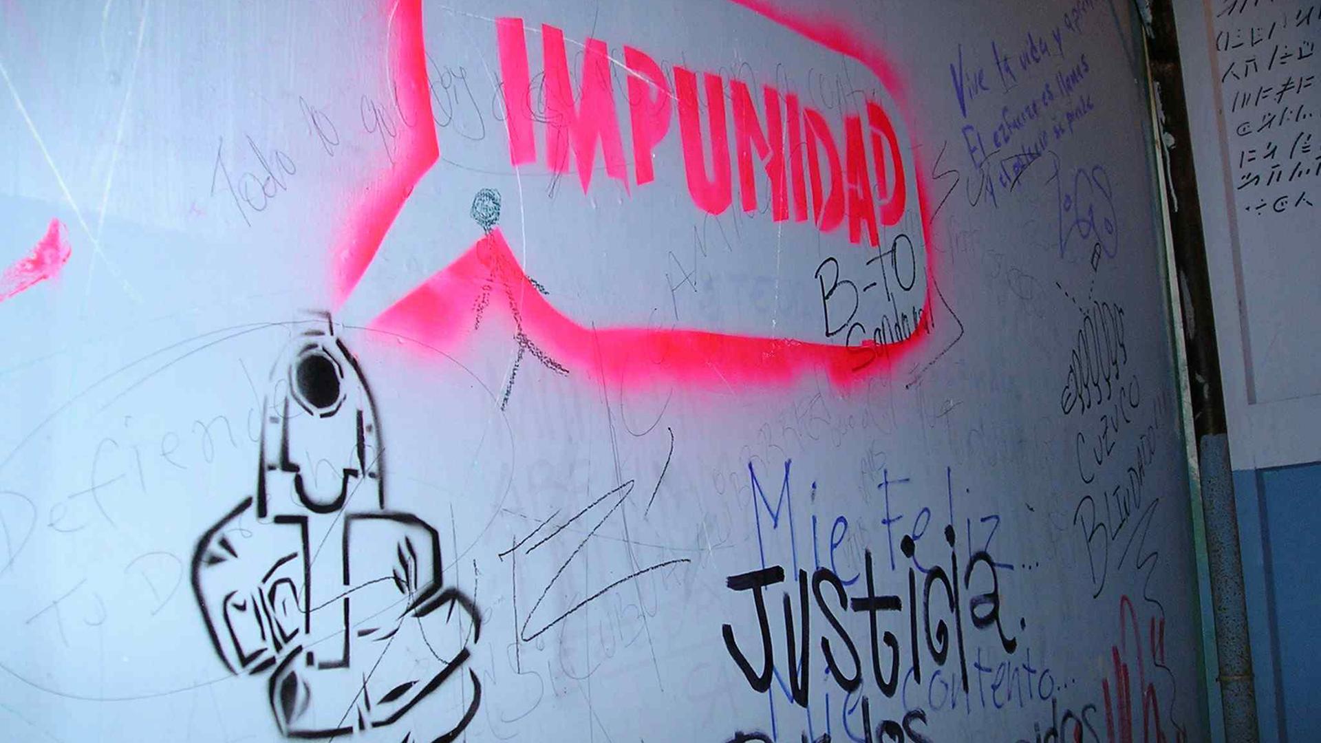 Graffiti als Anklage: Impunidad und dazu eine Pistole bedeutet Straffreiheit für die Mörder in der Diktatur.