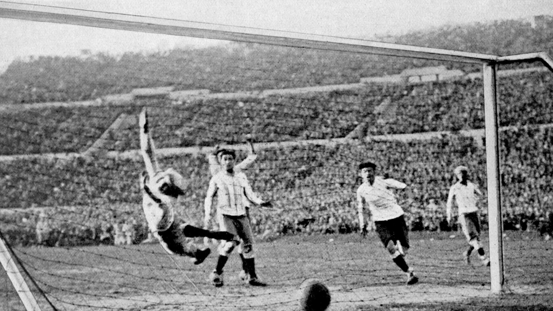 Der uruguayische Fußball-Nationalspieler Hector Castro (2. v. r.) erzielt das vierte Tor für seine Mannschaft während des Endspiels Uruguay-Argentinien (4:2) bei der Fußball-Weltmeisterschaft am 30.07.1930 in Montevideo. Argentiniens Torhüter Juan Botasso (l) springt vergeblich durch die Luft.