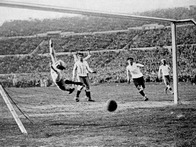 Der uruguayische Fußball-Nationalspieler Hector Castro (2. v. r.) erzielt das vierte Tor für seine Mannschaft während des Endspiels Uruguay-Argentinien (4:2) bei der Fußball-Weltmeisterschaft am 30.07.1930 in Montevideo. Argentiniens Torhüter Juan Botasso (l) springt vergeblich durch die Luft.