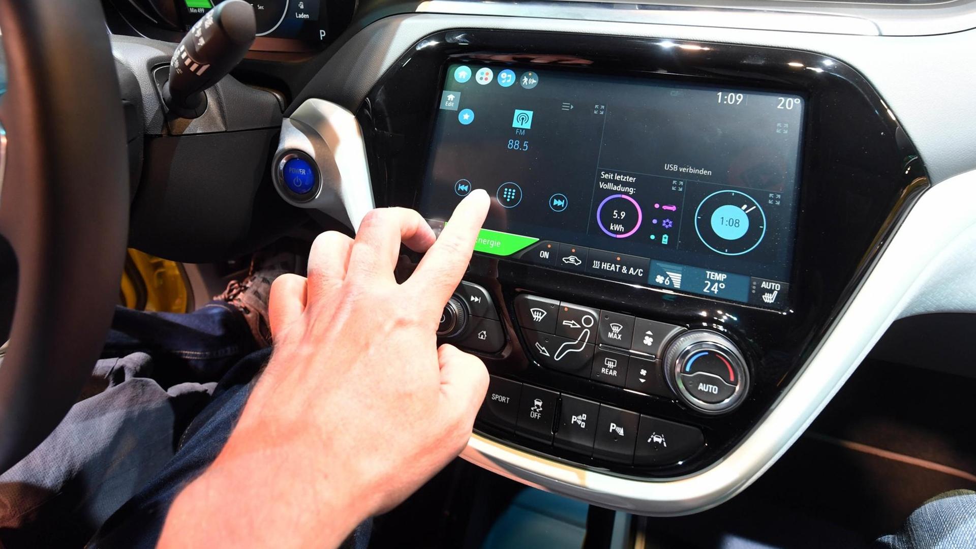 Sie sehen das Cockpit eines Elektroautos Opel "Ampera-e", das digital vernetzt ist.