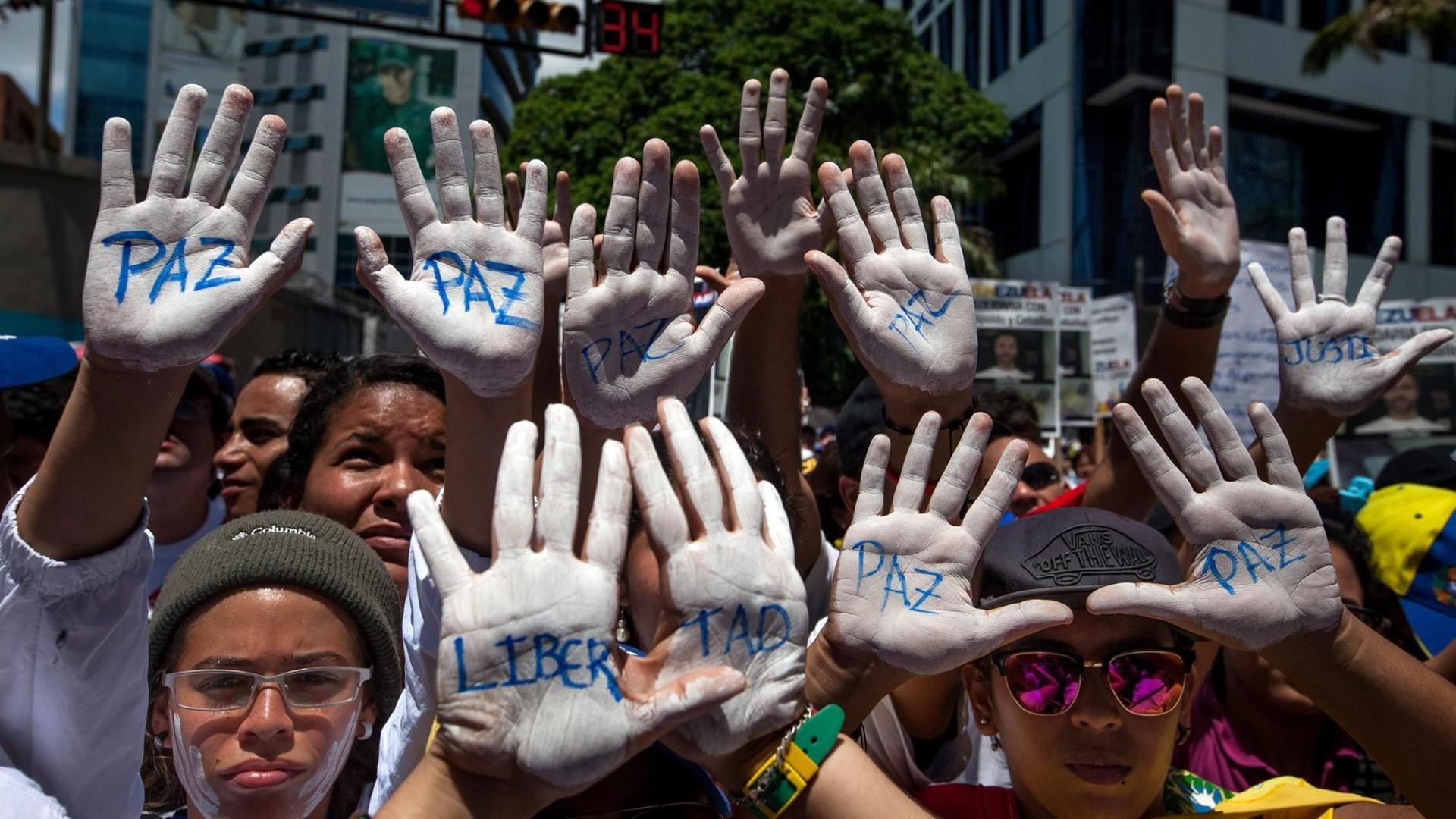 Demonstranten zeigen weiß gefärbte Hände in Caracas, 30.Mai 2015