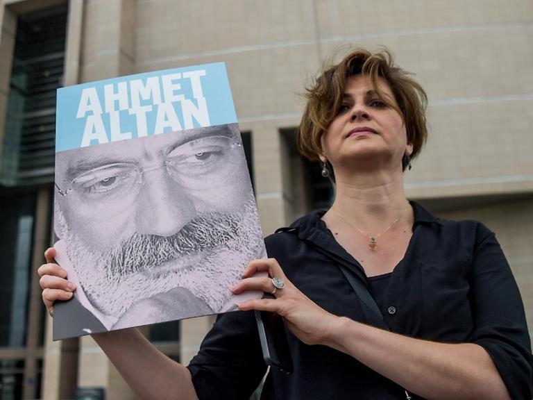Eine türkische Journalistin zeigt ein Foto ihres Kollegen Ahmet Altan, der mit einer Reihe von anderen Journalisten in Istanbul vor Gericht steht.