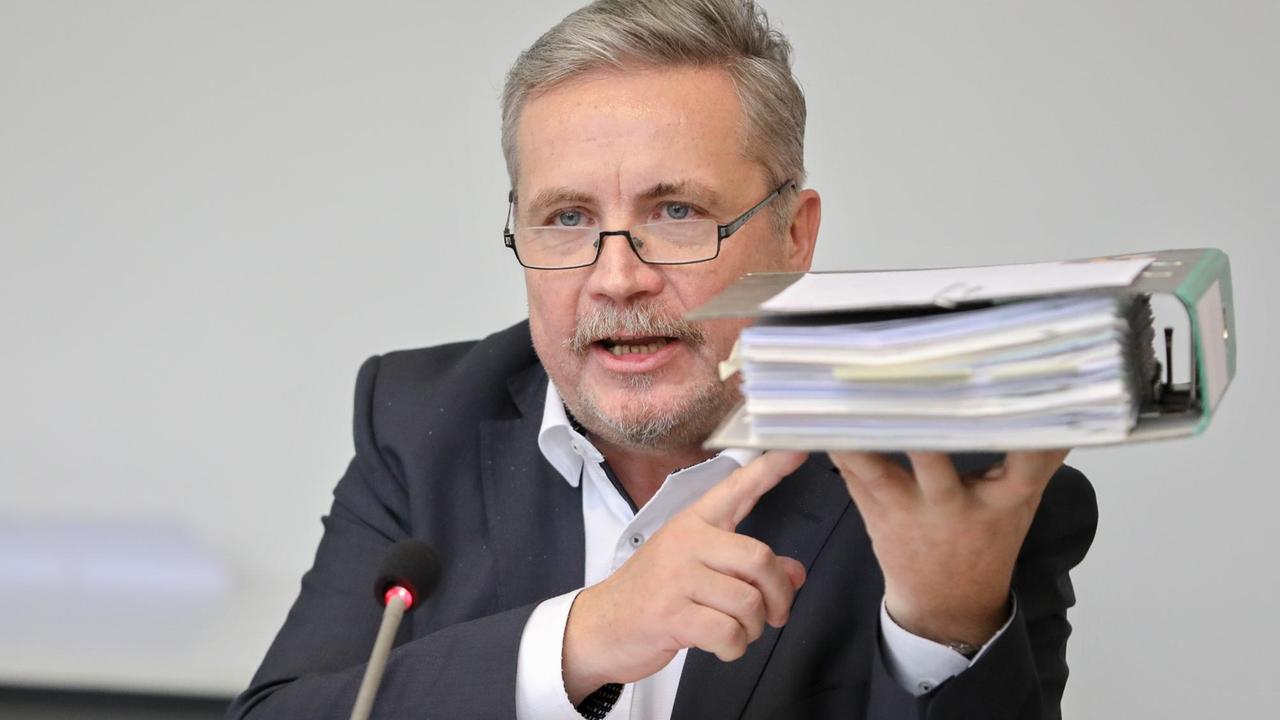 Rolf Schmidt, Oberbürgermeister von Annaberg-Buchholz in Sachsen, hält einen Ordner mit Papieren in die Höhe. 
