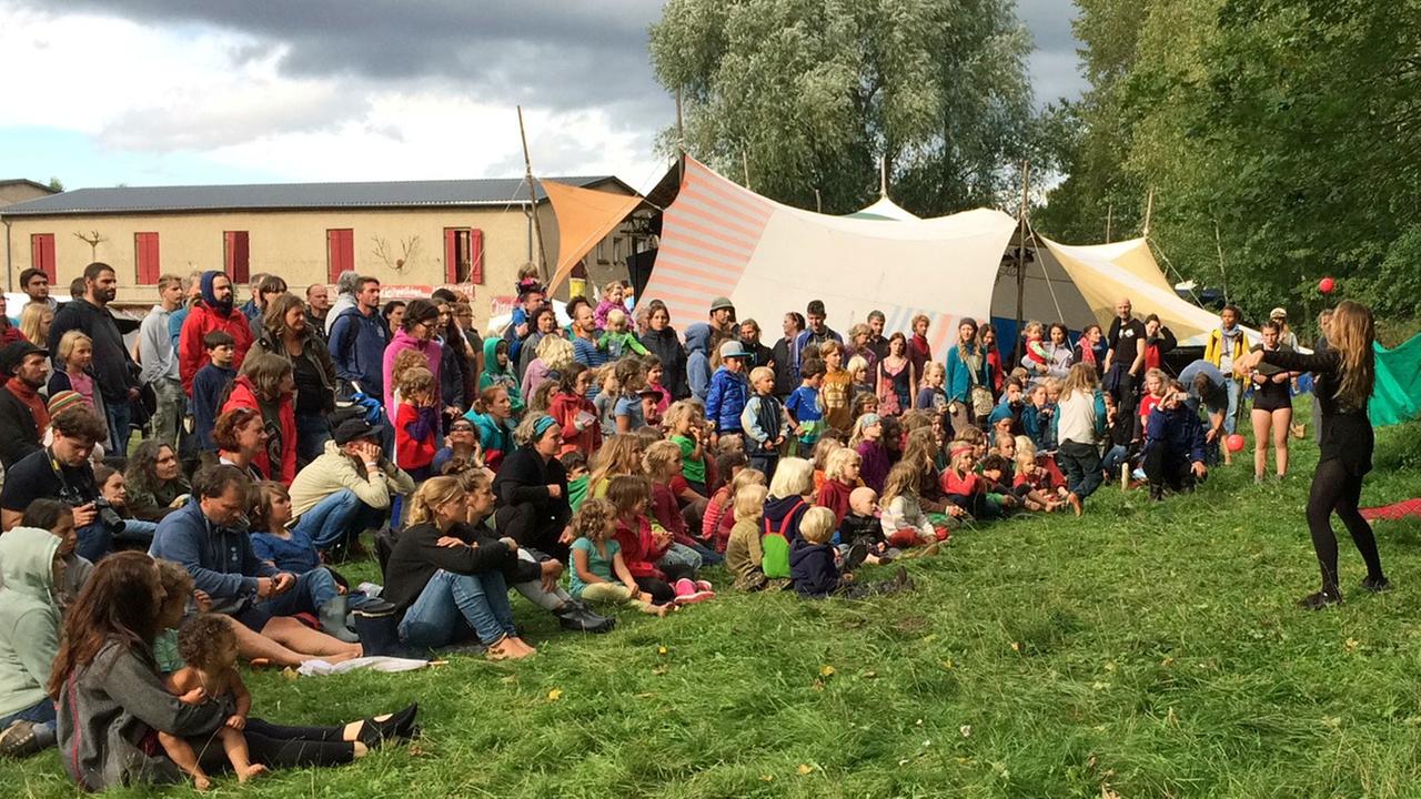"Schulfrei-Festival" in Brandenburg: Kinder und Erwachsene schauen einem Mädchen beim Jonglieren zu.