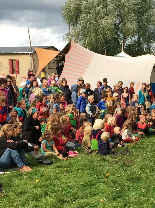 "Schulfrei-Festival" in Brandenburg: Kinder und Erwachsene schauen einem Mädchen beim Jonglieren zu.