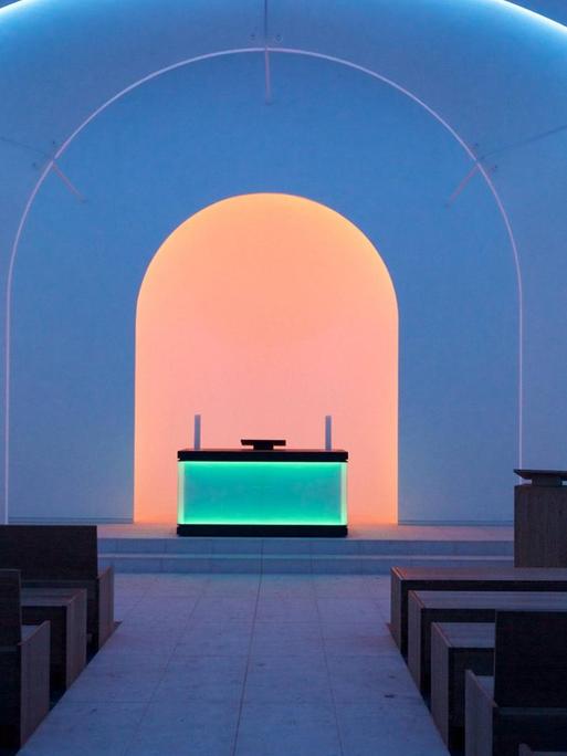 Lichtinstallation des US-amerikanischen Künstlers James Turrell in der Dorotheenstädtischen Friedhofskapelle. Der Altar, ein Kubus aus Acrylglas mit Leuchtdioden, bildet eine eigene Lichtquelle. Gemeinsam mit anderen Lichtquellen im Raum entsteht eine traumähnliche Atmosphäre.