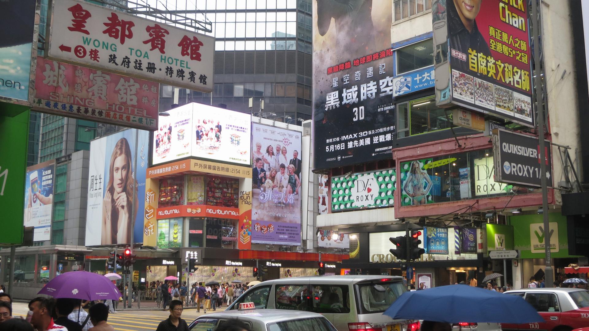 Reklame dominiert die Hausfassaden der Hauptstraße Nathan Road in Kowloon, ein Festland-Stadtteil von Hongkong, Aufnahme von 2013