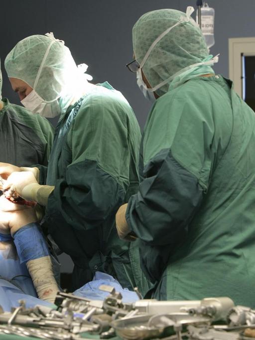 Ärzte setzen einem Patienten ein künstliches Kniegelenk ein