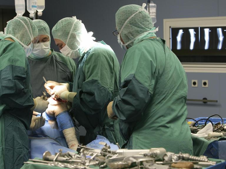 Ärzte setzen einem Patienten ein künstliches Kniegelenk ein