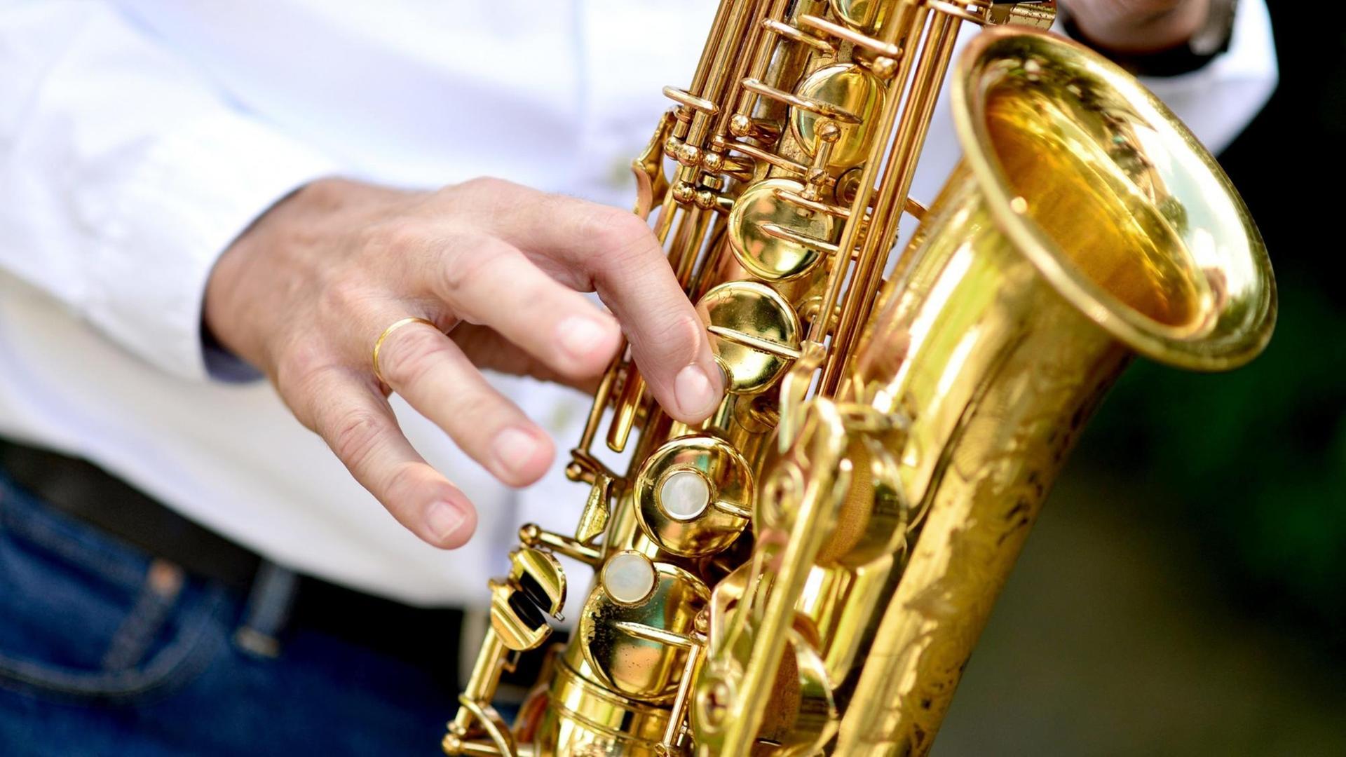 Ein Musiker spielt während einer Feier auf einem Saxophon.