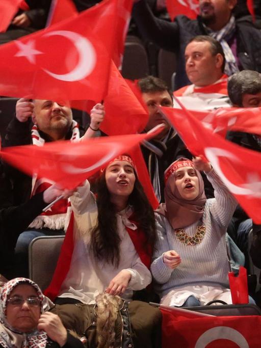 Teilnehmer bei einer Veranstaltung mit dem türkischen Ministerpräsidenten Yildirim halten am 18.02.2017 in Oberhausen (Nordrhein-Westfalen) türkische Fahnen in den Händen.