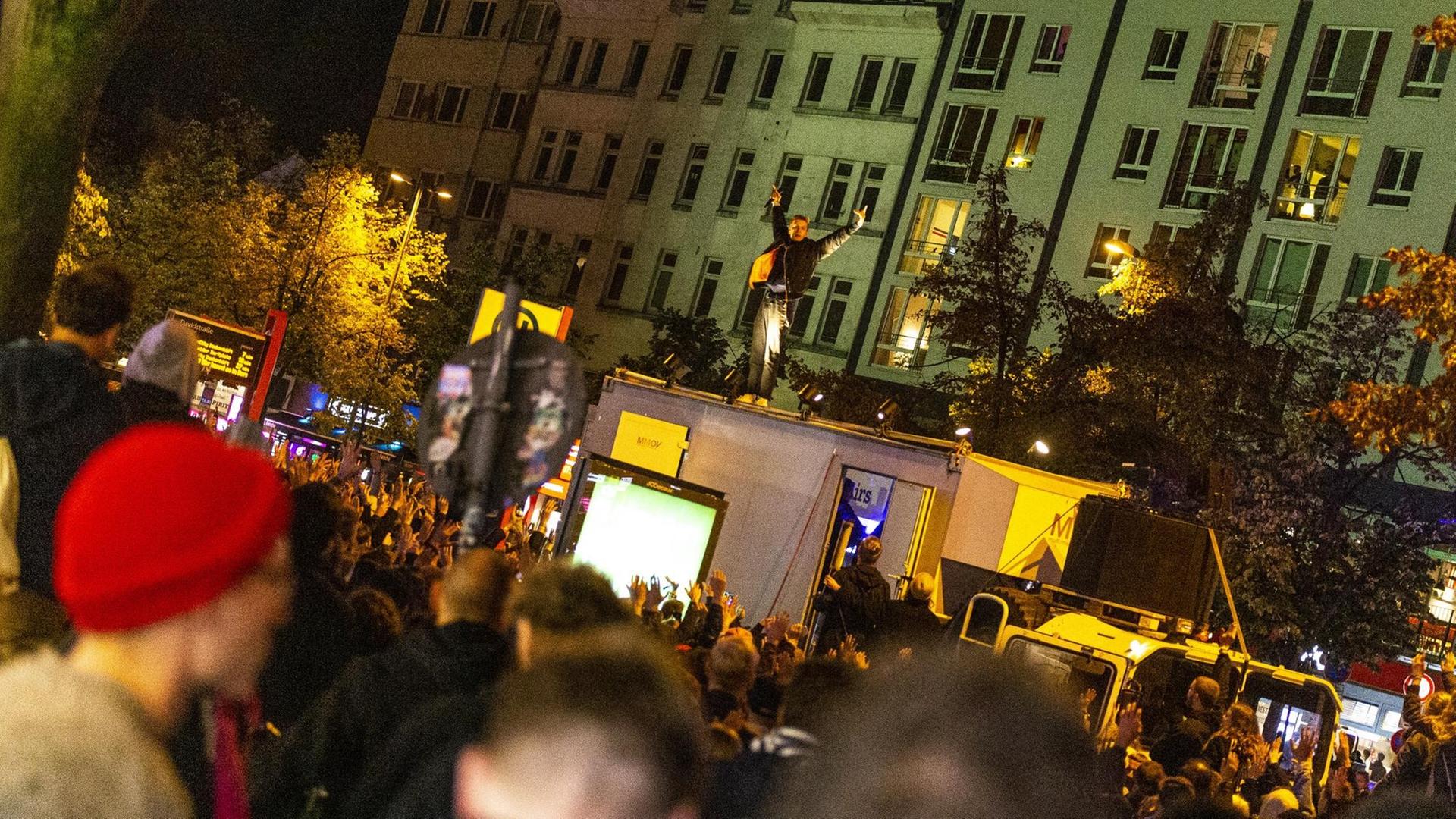 Felix Kummer singt auf dem Dach eines LKWs vor einer größeren Menge junger Menschen.