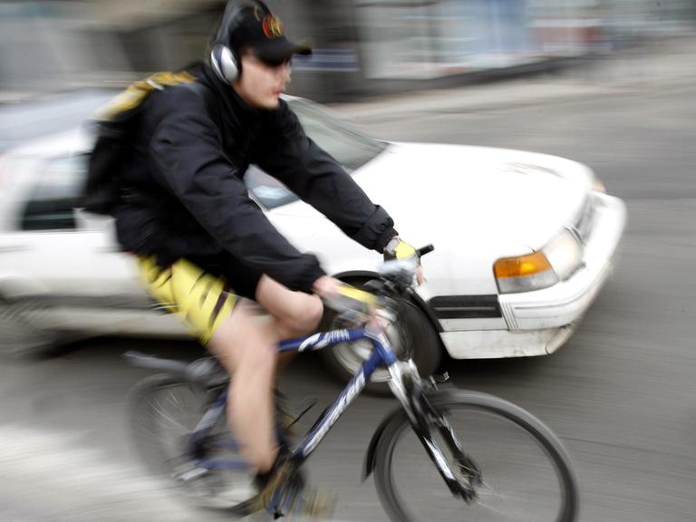 Radfahrer mit Kopfhörer im Straßenverkehr