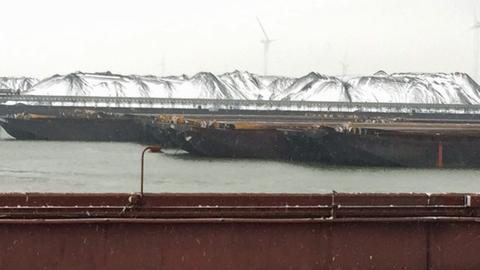 Wie verschneite Hügel: Bis zu 18 Meter hoch sind Erz- und Kohleberge am Erzumschlagterminal EECV im Rotterdamer Hafen
