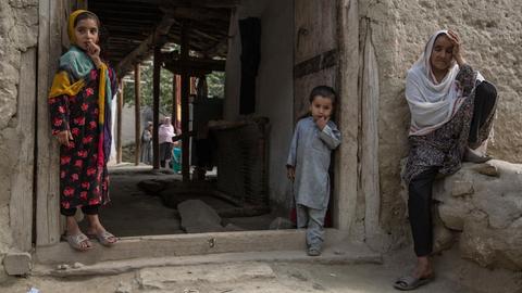 Eine afghanische Familie sitzt im Dorf Javari im Distrikt Khogyani im Süden der Provinz Nangarhar, Afghanistan vor ihrem Haus.