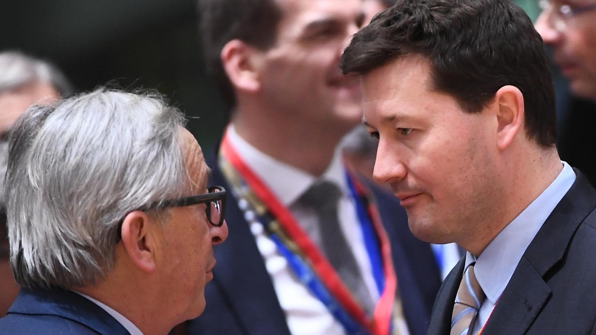 European Commission President Jean-Claude Juncker (L) speaks with new Secretary-General of the European Commission Martin Selmayr during a EU summit in Brussels on March 22, 2018 Juncker has reportedly threatened to resign as a controversy over the appointment of Selmayr as secretary-general continues to rage. / AFP PHOTO / Emmanuel DUNAND