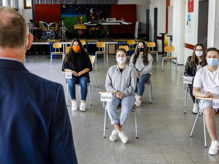 Schüler tragen Masken beim Unterricht im Musikraum