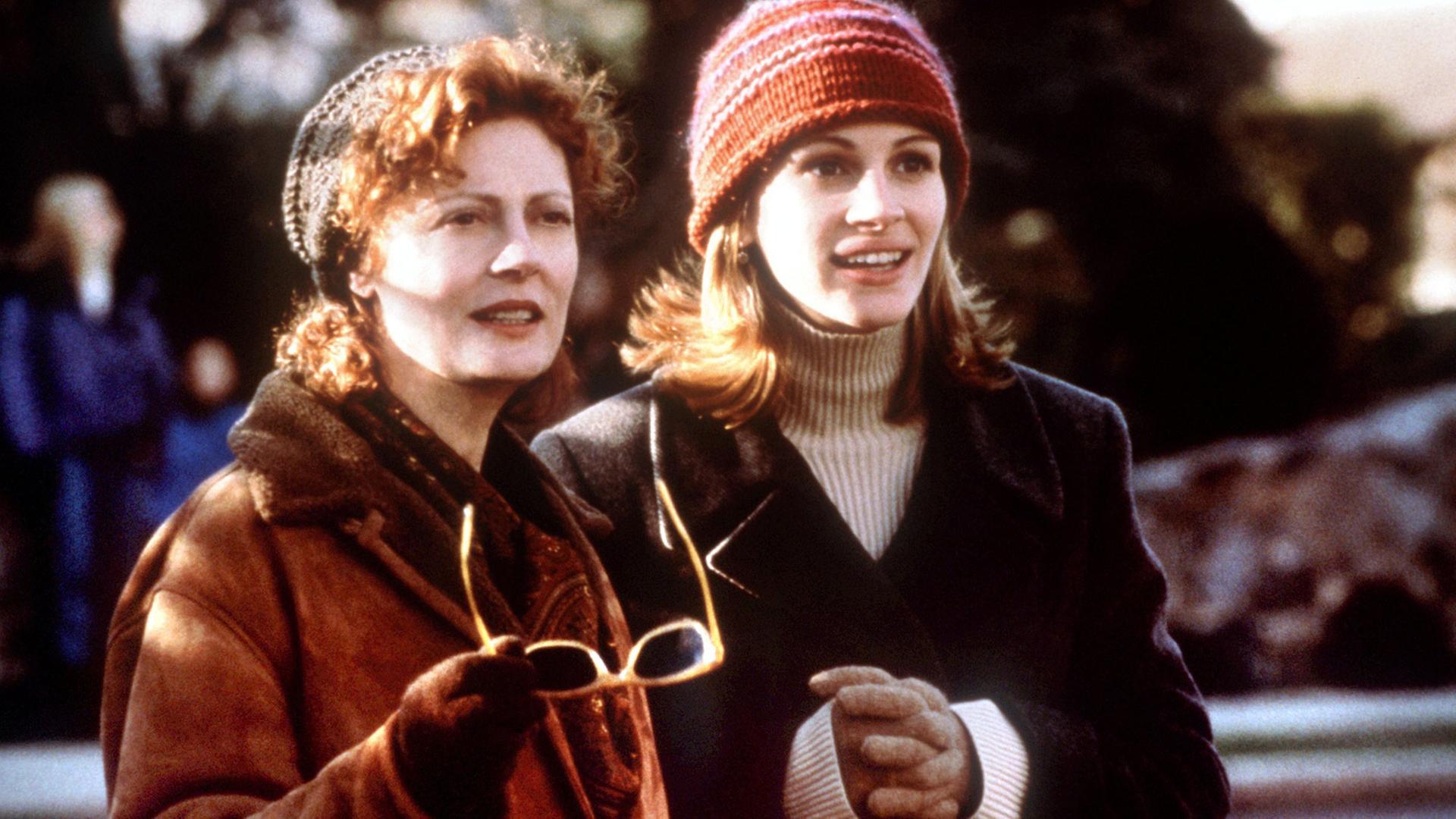 Die beiden US-amerikanischen Schauspielerinnen Julia Roberts (r) und Susan Sarandon in einer Szene des neuen Kinofilms "Seite an Seite", der am 28.1.1999 in die Kinos kommt. Inhalt: Isabel (Julia Roberts), eine erfolgreiche Werbefotografin, ist frisch verliebt. Doch mit ihrem Traummann Luke (Ed Harris) treten gleich drei weitere Menschen in ihr Leben: Lukes Kinder und seine Ex-Frau Jackie (Susan Sarandon). Als bei Jackie Krebs diagnostiziert wird, wendet sich das Blatt und die zwei Rivalinnen werden zu Freundinnen.