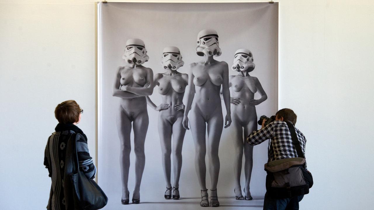 Eine Fotografie von Daniel Josefsohn betrachten sich zwei Besucher am in der Ausstellung des sechsten Fotografie-Festivals "f/stop" auf dem Gelände der Baumwollspinnerei in Leipzig.