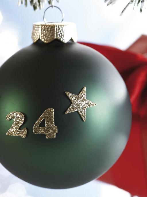 Grüne Christbaumkugel mit aufgedruckter "24" an Tannenzweig als Symbol für Heiligabend | Verwendung weltweit, Keine Weitergabe an Wiederverkäufer.
