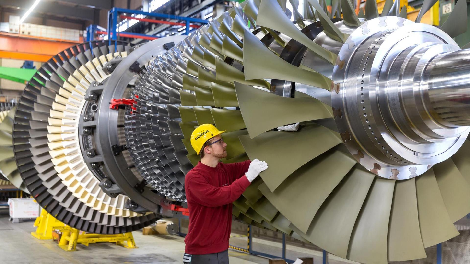 Ein Siemens-Mitarbeiter montiert eine Gasturbine