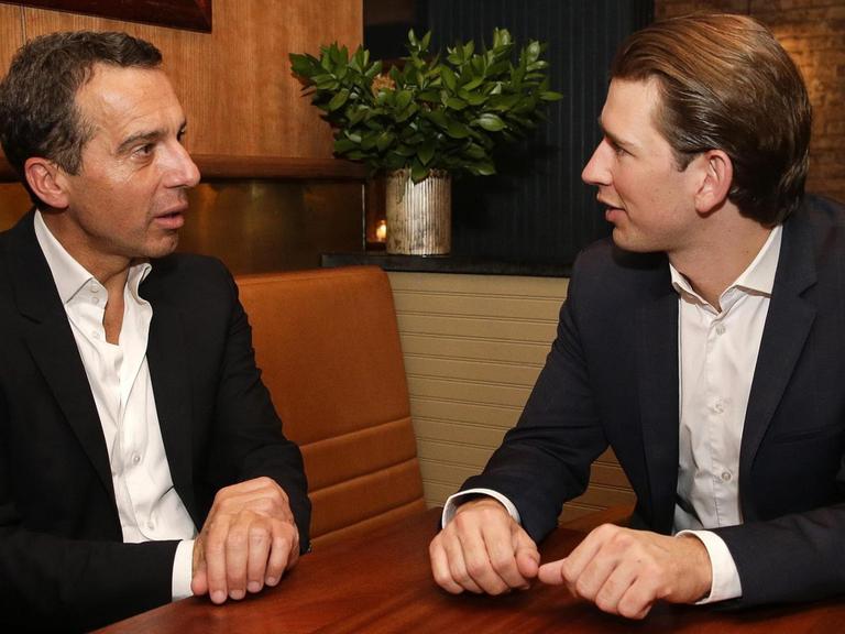 Der österreichischer Bundeskanzler Christian Kern (L) und Außenminister Sebastian Kurz unterhalten sich an einem Tisch während eines Aufenthaltes in New York am 18.09.2016