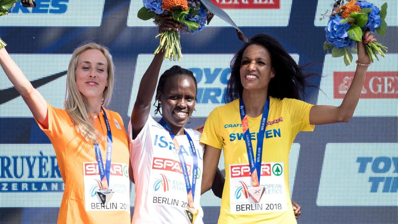 Leichtathletik, Europameisterschaft, Siegerehrung auf der Europäischen Meile am Breitscheidplatz: 10000 Meter, Frauen: Goldmedaillengewinnerin Lonah Chemtai Salpeter (M) aus Israel, Silbermedaillengewinnerin Susan Krumins (l) aus den Niederlanden und Bronzemedaillengewinnerin Meraf Bahta (r) aus Schweden.